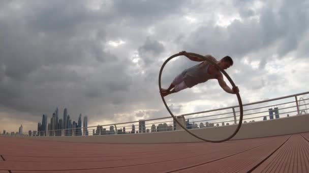 Cyr Wheel καλλιτέχνης με φόντο αστικό τοπίο του Ντουμπάι κατά τη διάρκεια του ηλιοβασιλέματος — Αρχείο Βίντεο