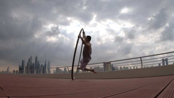 Cyr Wheel καλλιτέχνης με φόντο αστικό τοπίο του Ντουμπάι κατά τη διάρκεια του ηλιοβασιλέματος — Αρχείο Βίντεο