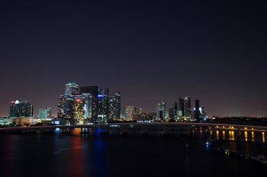 Miami şehir manzarası panorama ile kentsel gökdelenler ve köprüden denize ile yansıma alacakaranlıkta