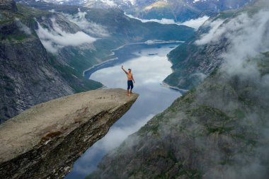 Cesur adam kenarda Trolltunga 'da selfie yapıyor. Norveç