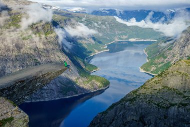 Uçurumun kenarında oturan cesur adam Trolltunga. Norveç