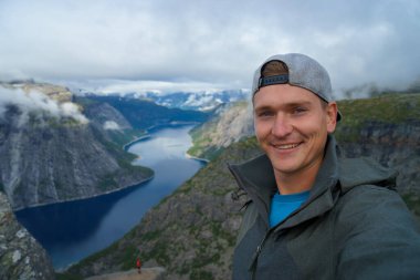 Norveç'te arka plan üzerinde güzel fiyort ile üst selfie alarak genç gezgin