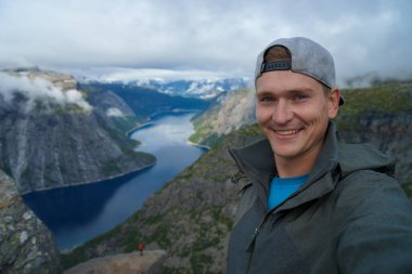Norveç'te arka plan üzerinde güzel fiyort ile üst selfie alarak genç gezgin