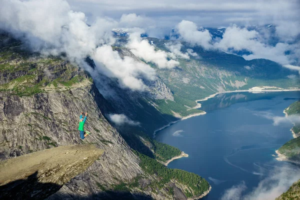 Jovem salte na borda Trolltunga. Noruega — Fotografia de Stock
