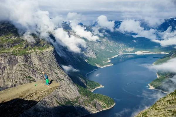 Turnster staande op zijn handen op de rand met fjord op achtergrond in de buurt van de Trolltunga. Noorwegen — Stockfoto