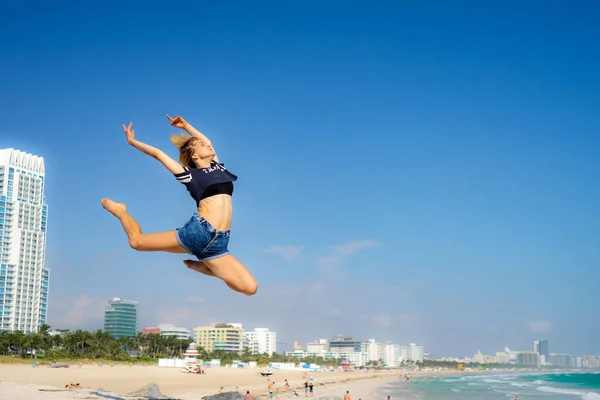 Гарна дівчина стрибає з Південним Бічем на задньому плані, Маямі Біч. Флорида. Концепція щастя і свободи — стокове фото