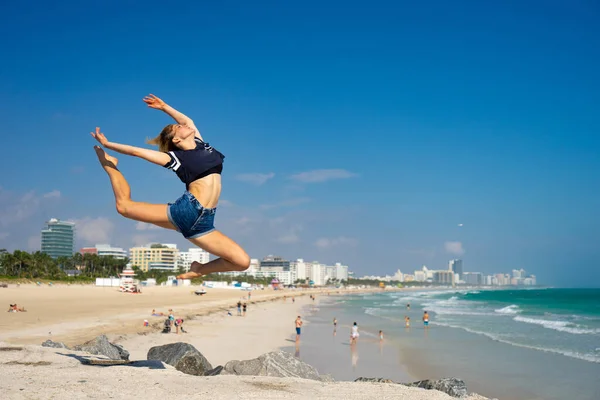 Hermosa chica salto con South Beach en el fondo, Miami Beach. Florida. Concepto de felicidad y libertad — Foto de Stock