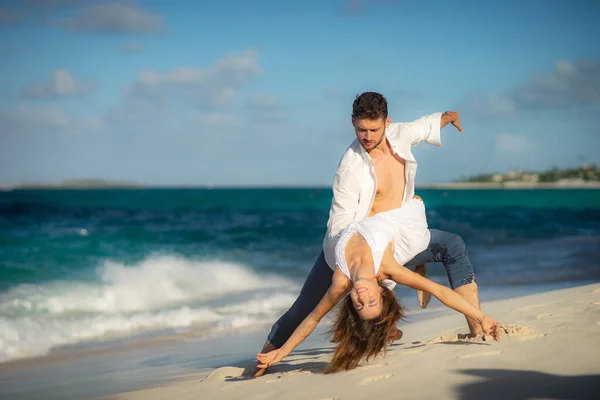 Pareja amorosa bailando en la arena en la playa del mar en verano contra las olas surf — Foto de Stock