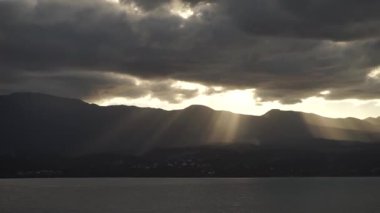 Dramatik bir gün batımı. Denizde dağların üzerinde güzel ışınlar. Guadeloupe Adası