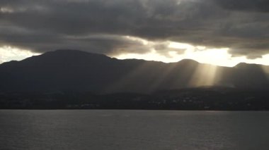 Dramatik bir gün batımı. Denizde dağların üzerinde güzel ışınlar. Guadeloupe Adası