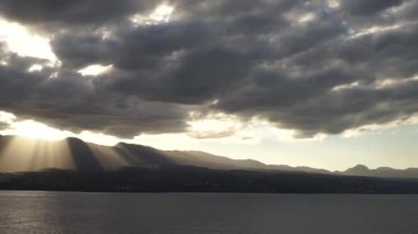 Dramatik bir gün batımı. Denizde dağların üzerinde güzel ışınlar. Guadeloupe Adası