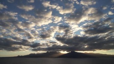 Dramatik bir gün batımı. Denizde dağların üzerinde güzel ışınlar. Guadeloupe Adası