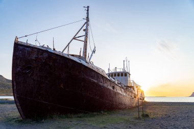 Gün batımında plajda Latrabjarg 'a düşen bir balina avlama gemisi.