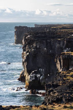 Tehlikeli dikey uçurumlu deniz manzarası, gün batımında bulutlu manzara