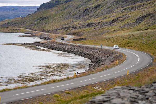 Живописный пейзаж с автомобилями, движущимися по красивой дороге, заливом и береговой линией от исландского Вестминстера — стоковое фото