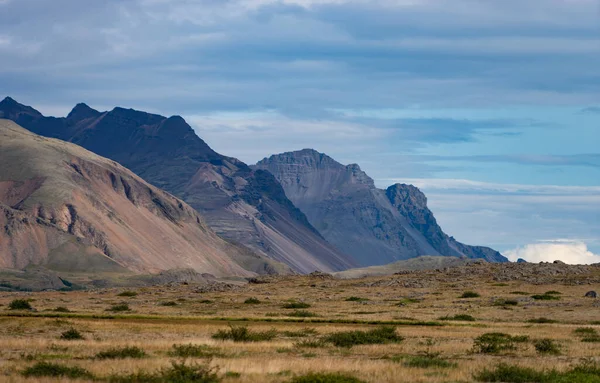 Izlandi táj hegyekkel, kék égbolttal és zöld fűvel az előtérben. Nyugati fjord rész — Stock Fotó