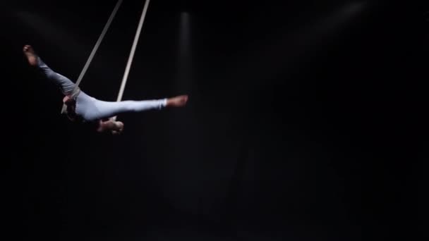 Musclé cirque aerialist sur les sangles aériennes en studio noir — Video