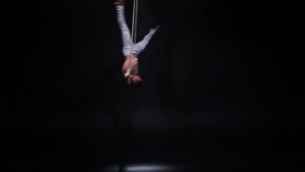 Мускулистый циркач на воздушных ремнях в черной студии — стоковое видео