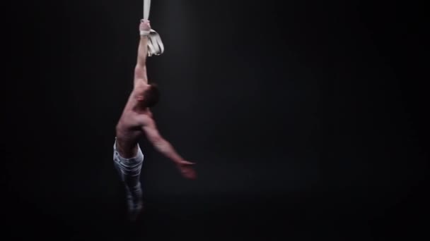 Siyah stüdyodaki hava kayışlarında kaslı sirk akeryalisti — Stok video
