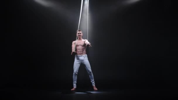 4k Muscular circus aerialist on the aerial straps in black studio — Stock Video