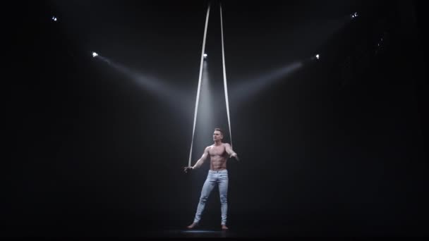 4k Aerialista de circo muscular en las correas aéreas en estudio negro — Vídeo de stock