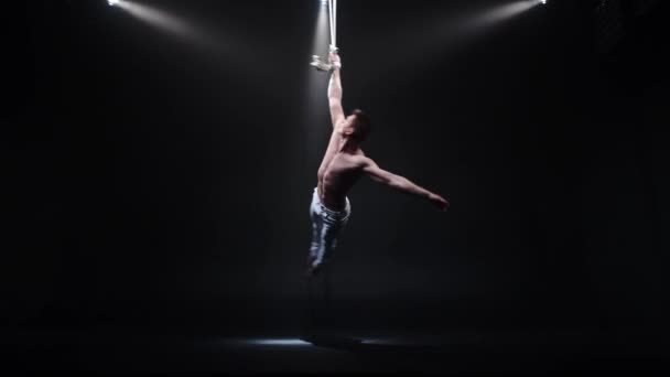 4k Aerialista de circo muscular en las correas aéreas en estudio negro — Vídeos de Stock