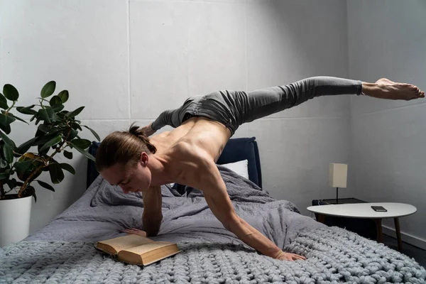 Gymnast reading book and keep balance on the hand in horizontal position. Concept of self-development, motivation and education