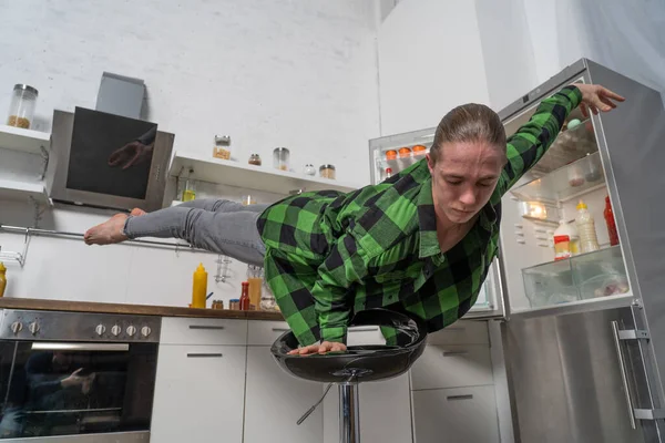 肌肉男在厨房的一只手上保持平衡.健康生活方式和有机食品的概念 — 图库照片