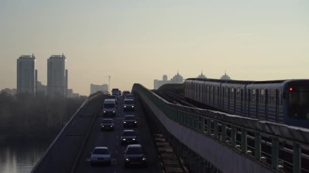 Kiev, Ucrânia. Ponte de metro através do rio Dnieper com trem e carros sobre ele — Vídeo de Stock
