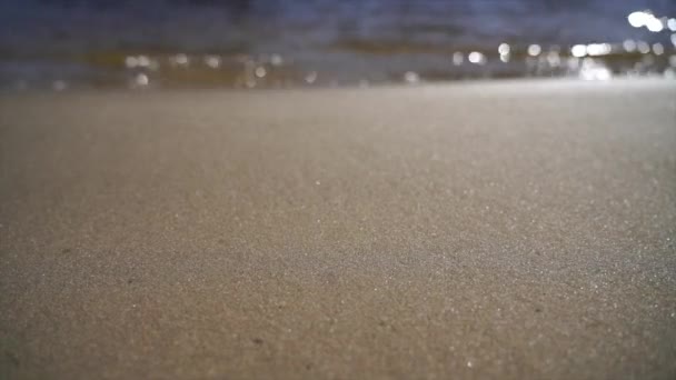 Cámara lenta de agua cristalina y arena dorada — Vídeo de stock