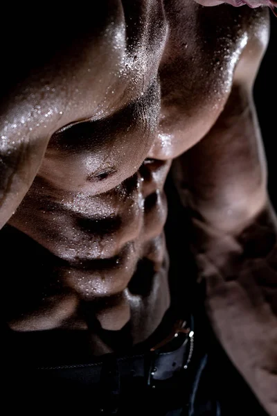Svalnatý muž ukazující svaly izolované na černém pozadí. Koncept zdravého životního stylu — Stock fotografie