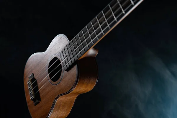 Guitarra ukelele Hawaii aislada sobre fondo negro con humo — Foto de Stock