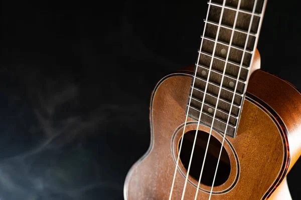 Guitarra ukelele Hawaii aislada sobre fondo negro con humo — Foto de Stock