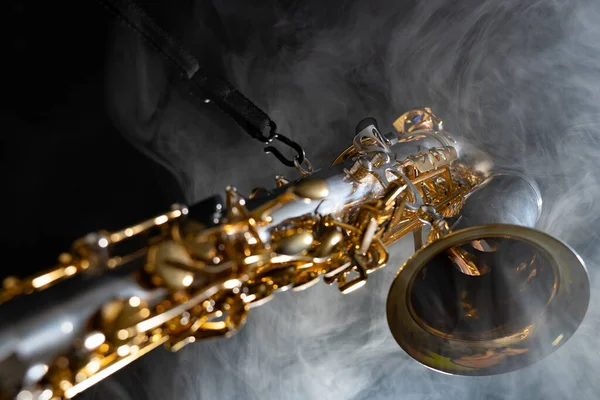 Saxofón alto dorado brillante sobre fondo negro con humo. espacio de copia —  Fotos de Stock