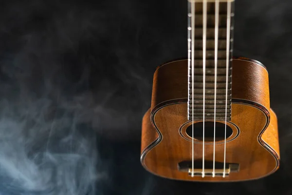 Guitarra ukelele Hawaii aislada sobre fondo negro con humo — Foto de Stock