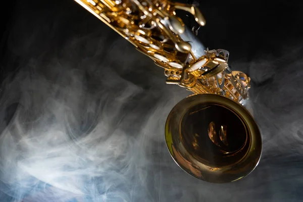 Saxofón alto dorado brillante sobre fondo negro con humo. espacio de copia — Foto de Stock