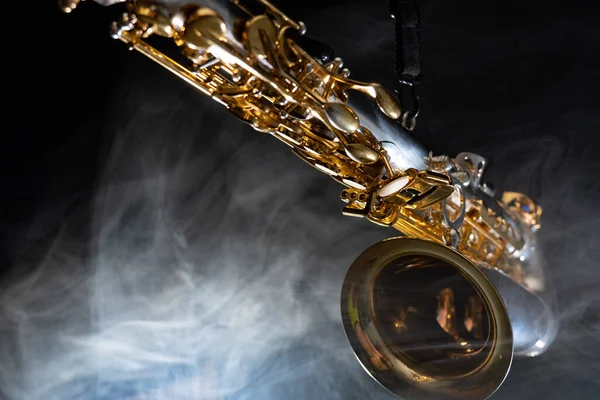 Saxofón alto dorado brillante sobre fondo negro con humo. espacio de copia — Foto de Stock