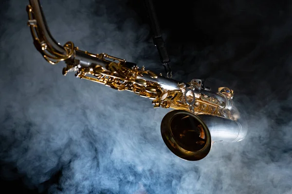 Saxofón alto dorado brillante sobre fondo negro con humo. espacio de copia —  Fotos de Stock