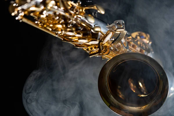 Saxofón alto dorado brillante sobre fondo negro con humo. espacio de copia — Foto de Stock