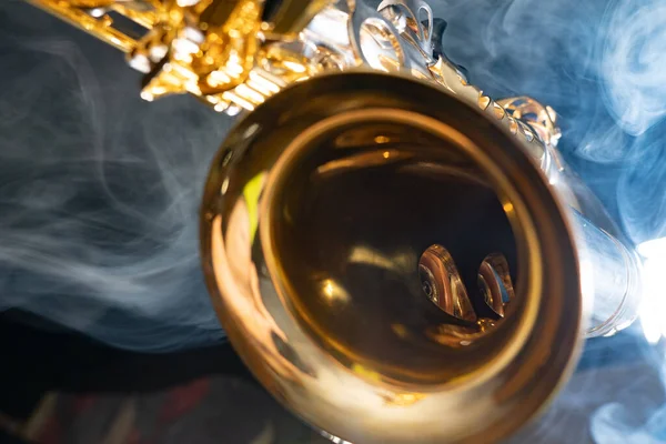 Saxofón alto dorado brillante sobre fondo negro con humo. espacio de copia —  Fotos de Stock