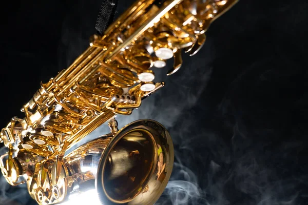 Golden shiny alto saxophone on black background with smoke. copy space — Stock Photo, Image