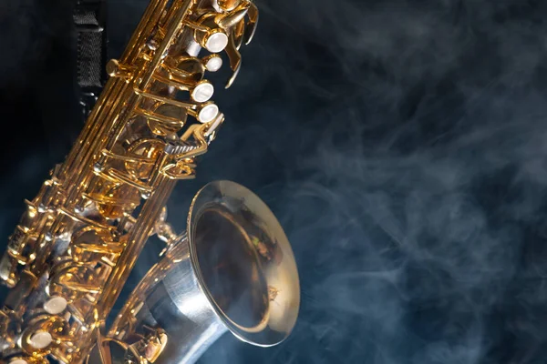 Saxofón alto dorado brillante sobre fondo negro con humo. espacio de copia —  Fotos de Stock