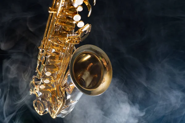 Saxofón alto dorado brillante sobre fondo negro con humo. espacio de copia —  Fotos de Stock