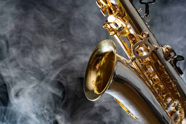 Saxofón alto dorado brillante sobre fondo negro con humo. espacio de copia — Foto de Stock