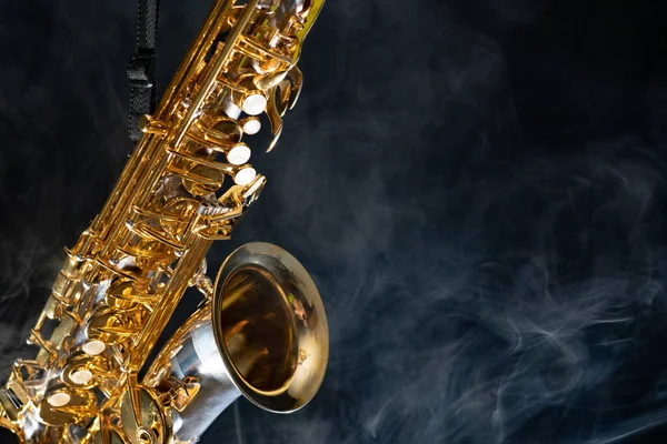 Saxofón alto dorado brillante sobre fondo negro con humo. espacio de copia —  Fotos de Stock