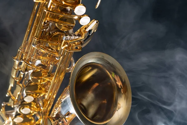 Golden shiny alto saxophone on black background with smoke. copy space — Stock Photo, Image