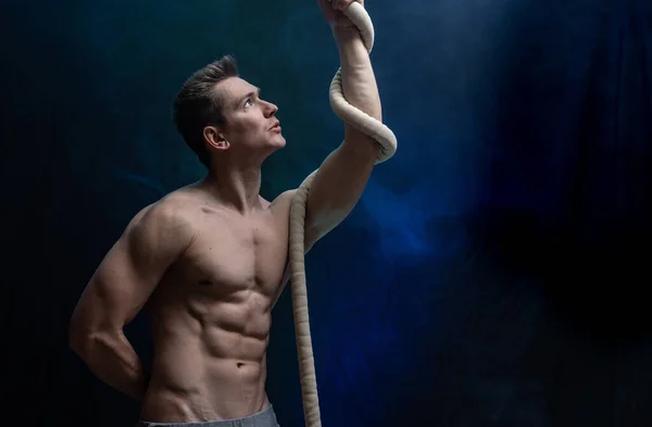 Мускулистий чоловічий цирковий артист з Кордом Ліссе на чорному задимленому тлі — стокове фото