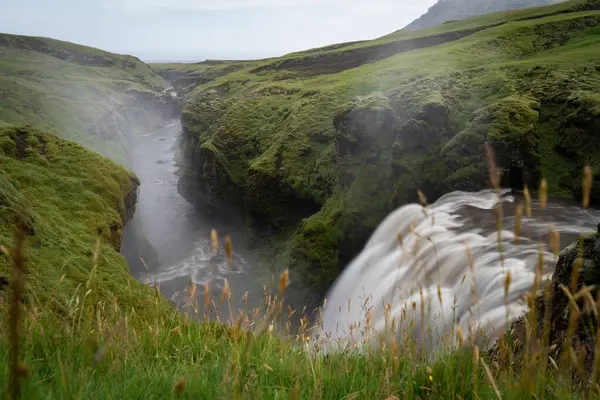 Hermosa cascada suave en Islandia rodeada de verdes colinas — Foto de Stock