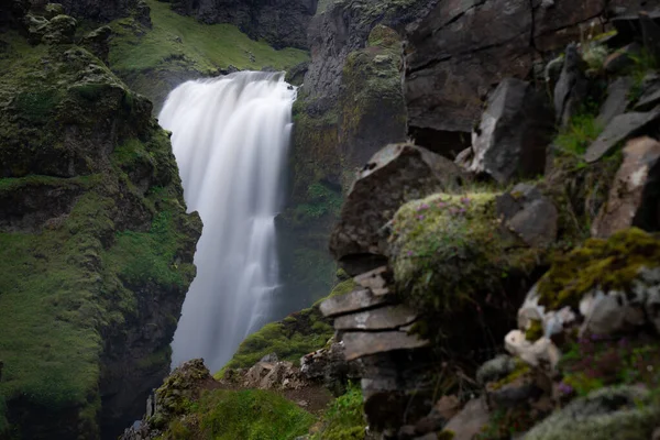 Schöner glatter Wasserfall in Island, umgeben von grünen Hügeln — Stockfoto