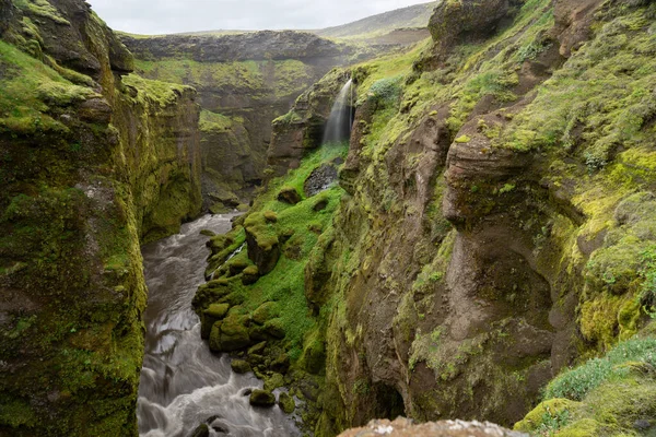 Krásná řeka s malým vodopádem na Islandu obklopená zeleným útesem — Stock fotografie